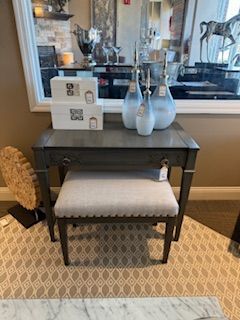A stool is sitting on top of a table next to a mirror.