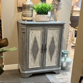 A gray and white cabinet with a plant on top of it in a room.