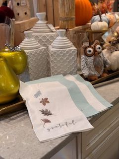 A towel with leaves on it is sitting on a counter.