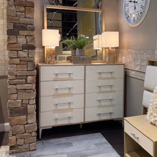 A room with a dresser and a clock on the wall