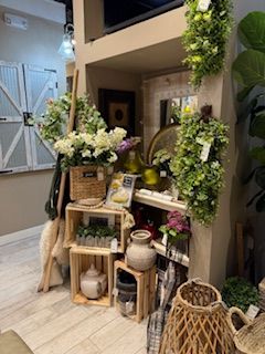 A room filled with lots of flowers and wicker baskets.