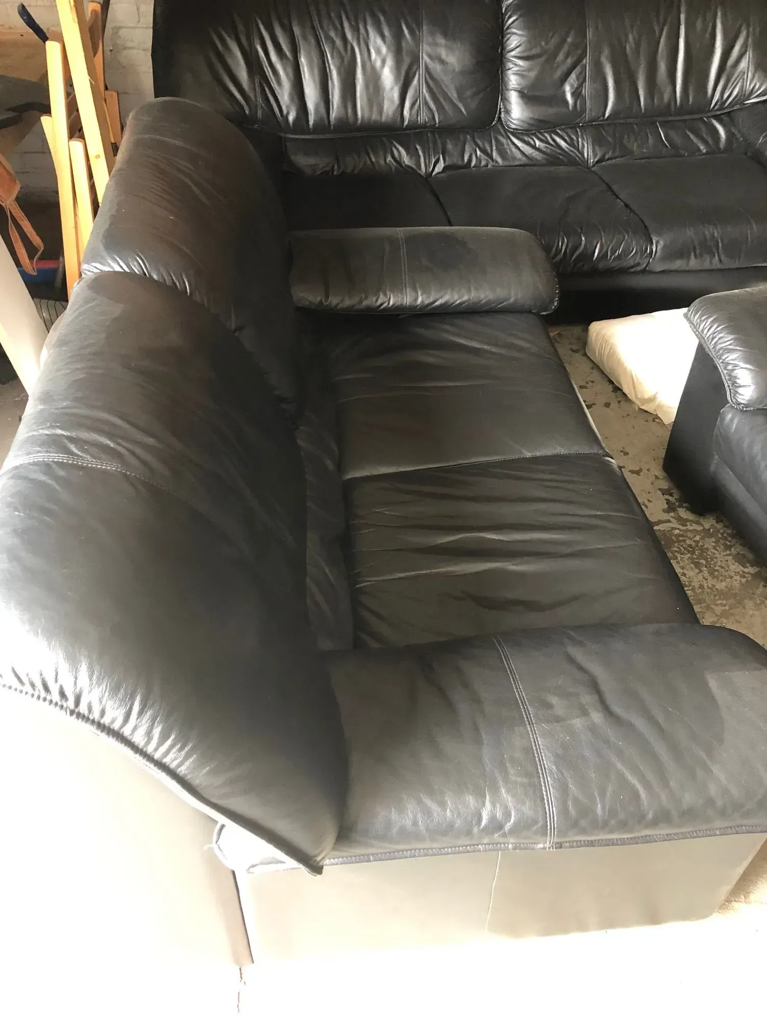 Black leather sectional sofa with a cushion in a living room