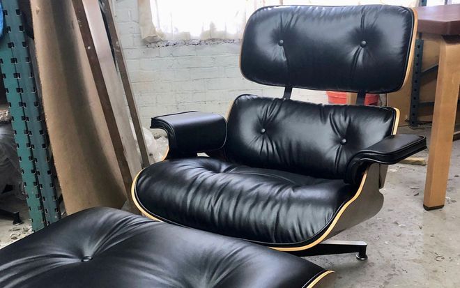 Black tufted lounge chair with ottoman in a workshop setting