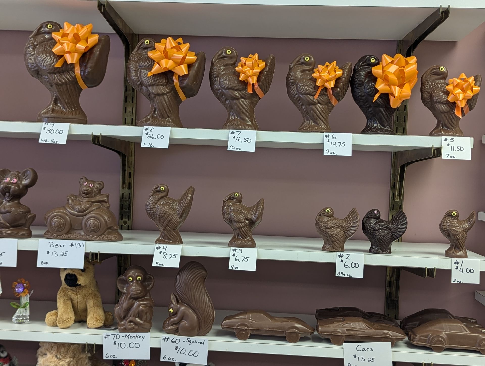 A shelf filled with chocolate figurines including a dog and a squirrel
