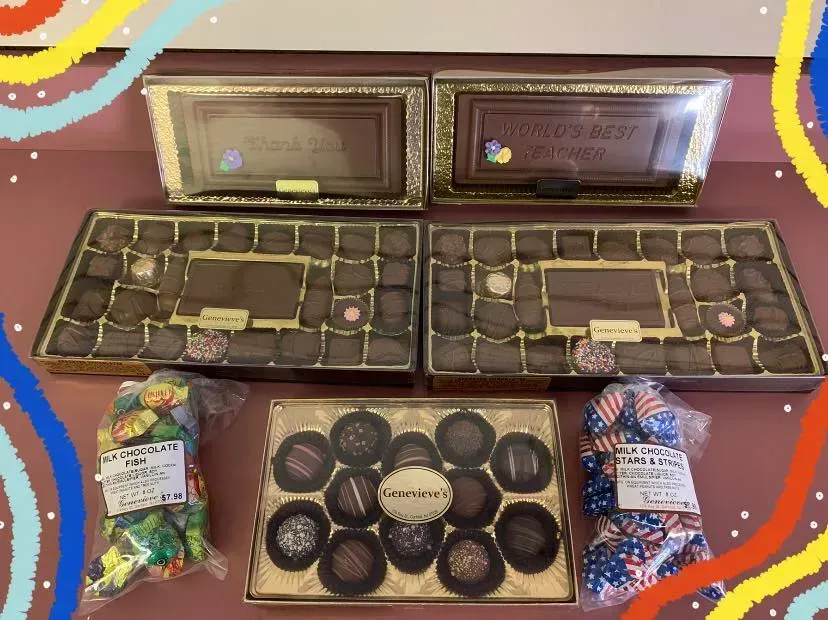 Two boxes of chocolates and a bag of candy on a table