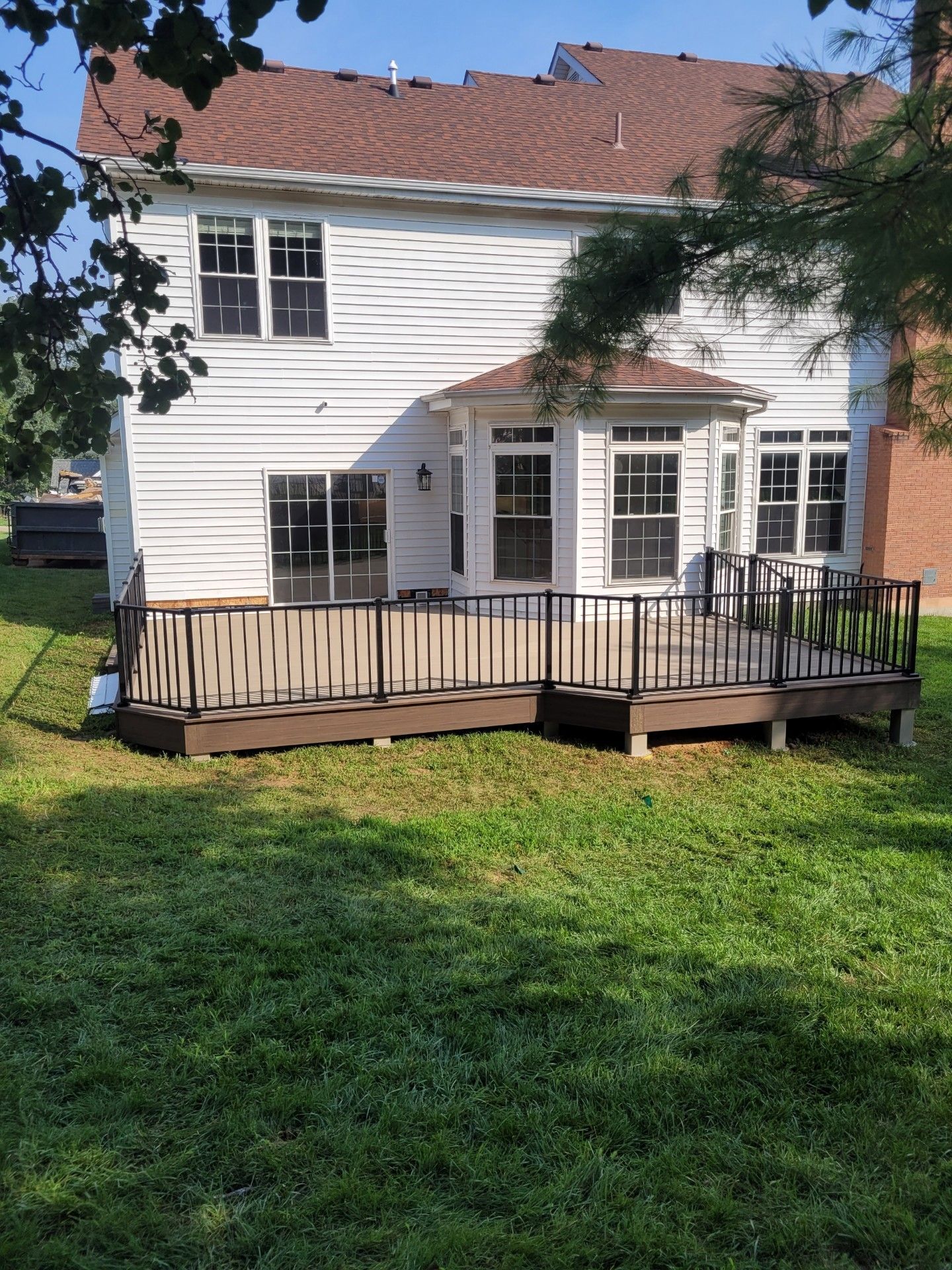 a white house with a large deck in the backyard