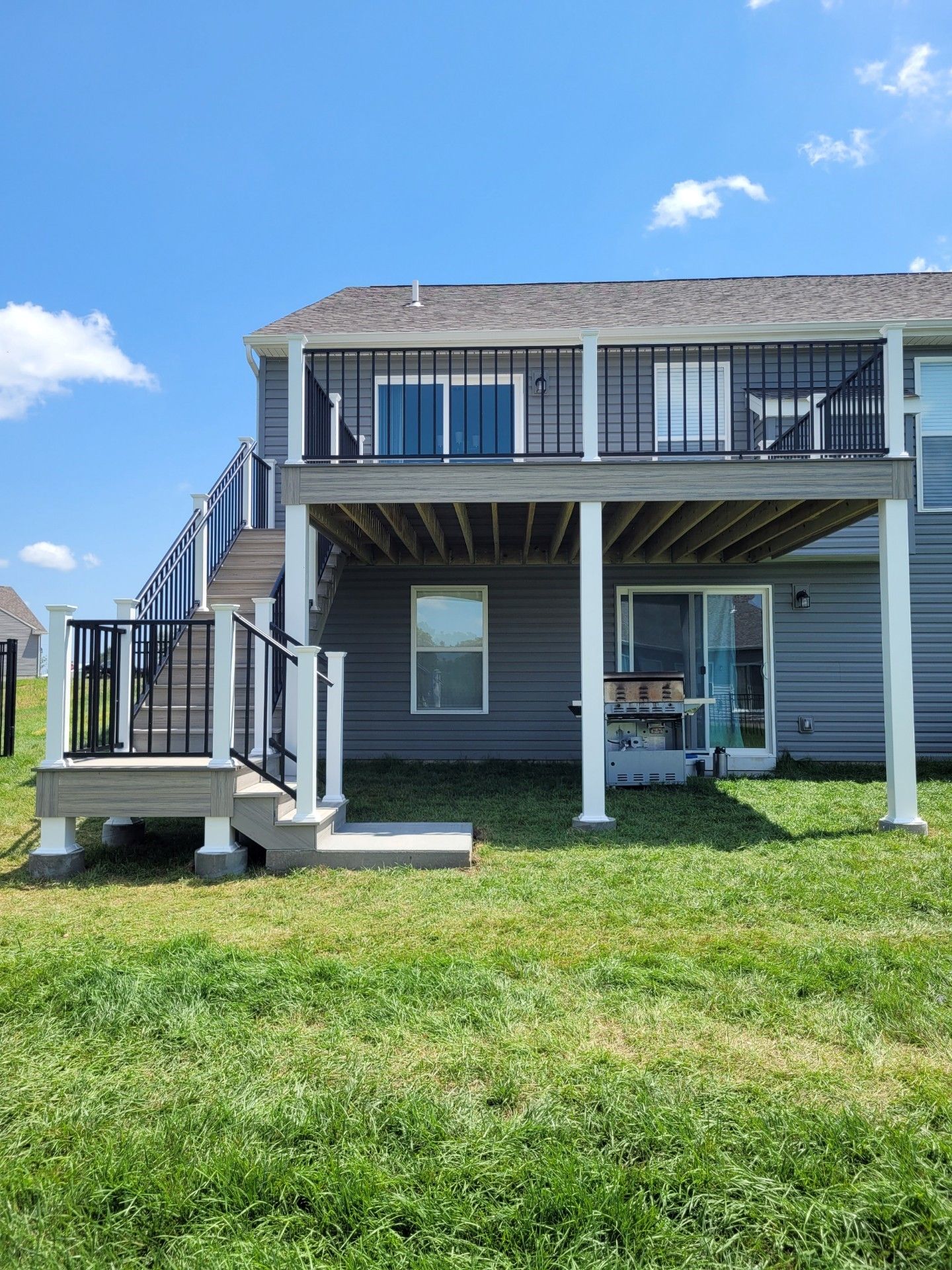 the back of a house with a large deck and stairs