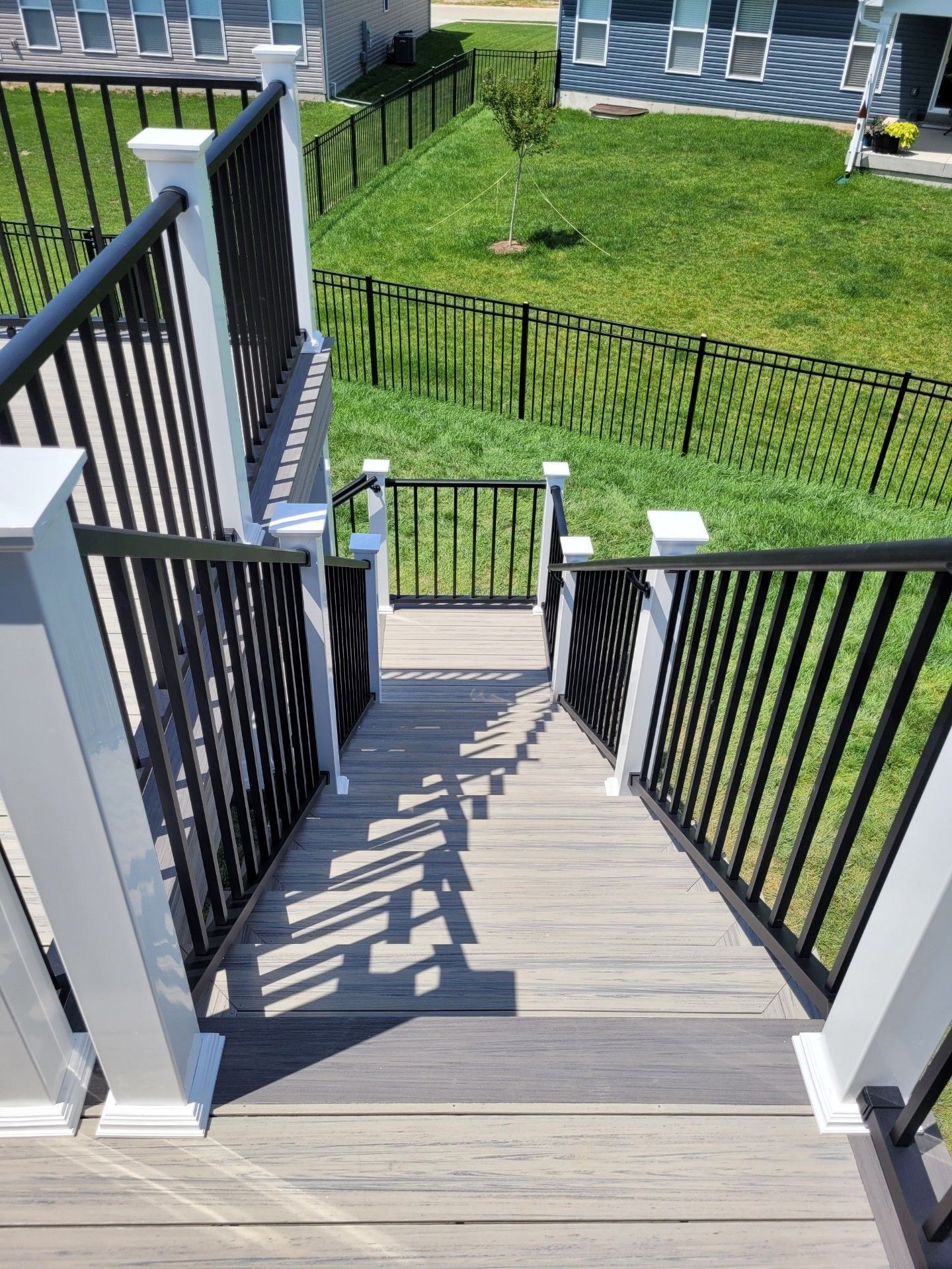 a staircase leading up to a deck with a black railing