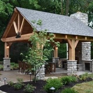 a wooden pavilion with a stone fireplace