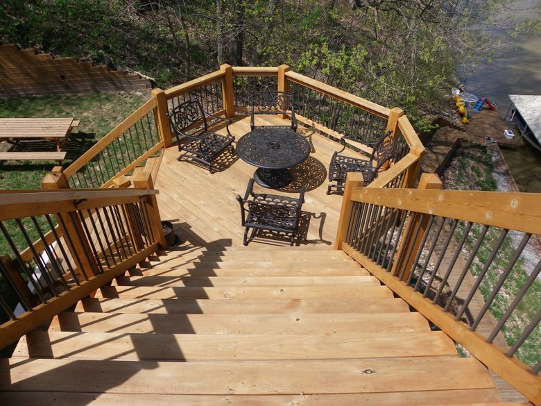 a wooden deck with a table and chairs on it