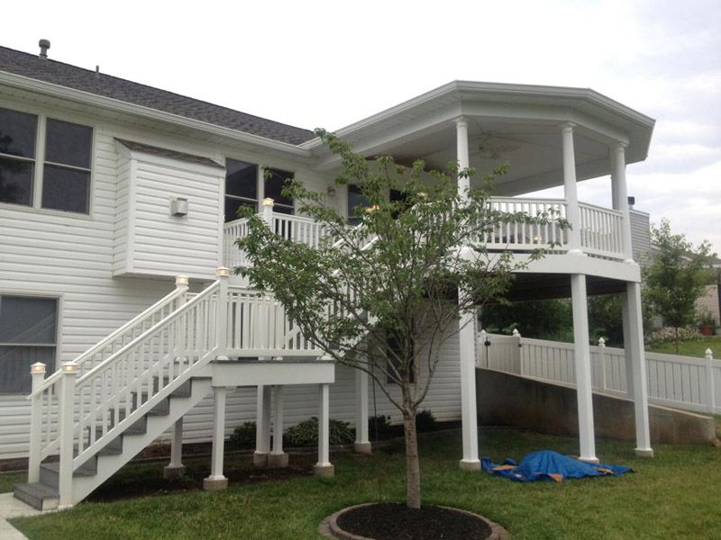 a white house with a white deck and stairs