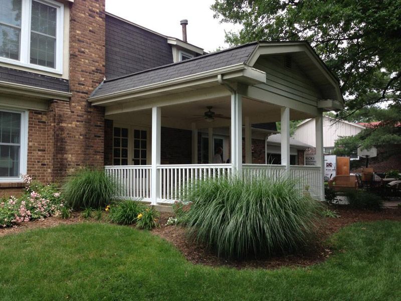 a brick house with a porch and a white railing
