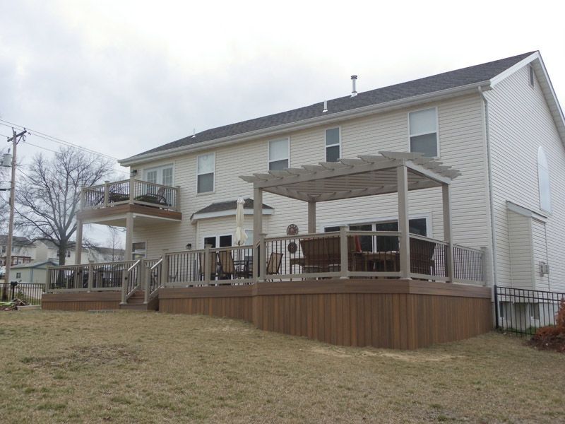 the back of a house with a deck and pergola