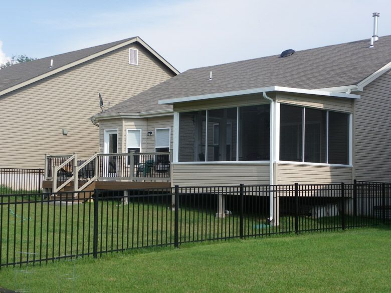 a screened porch in the backyard of a house