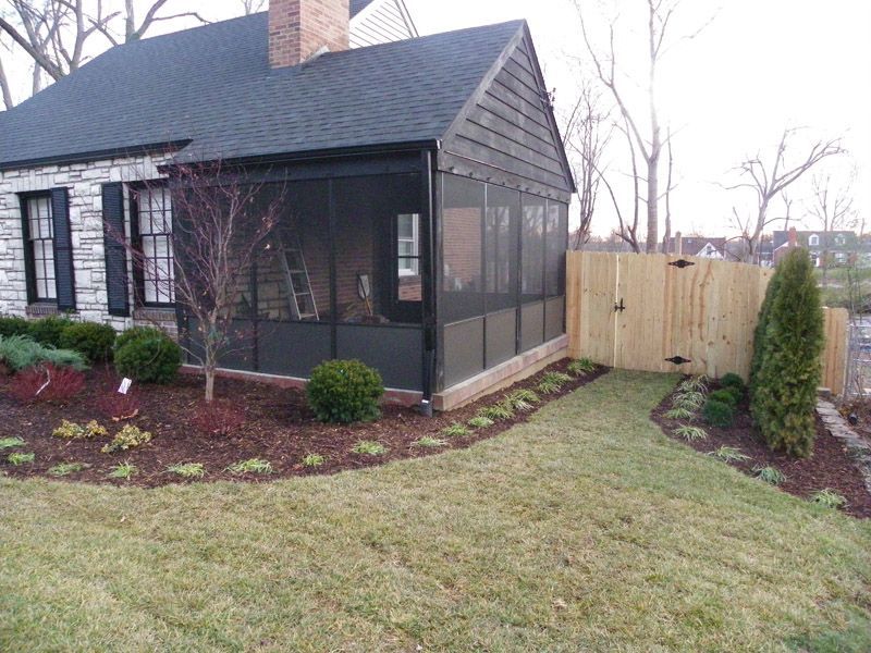 a house with a screened porch and a wooden fence