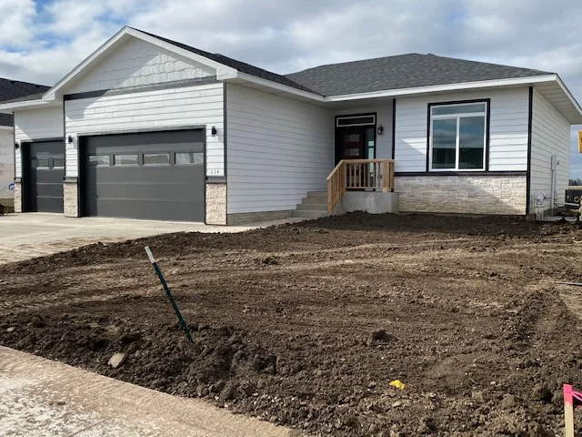 A house is being built with a lot of dirt in front of it.