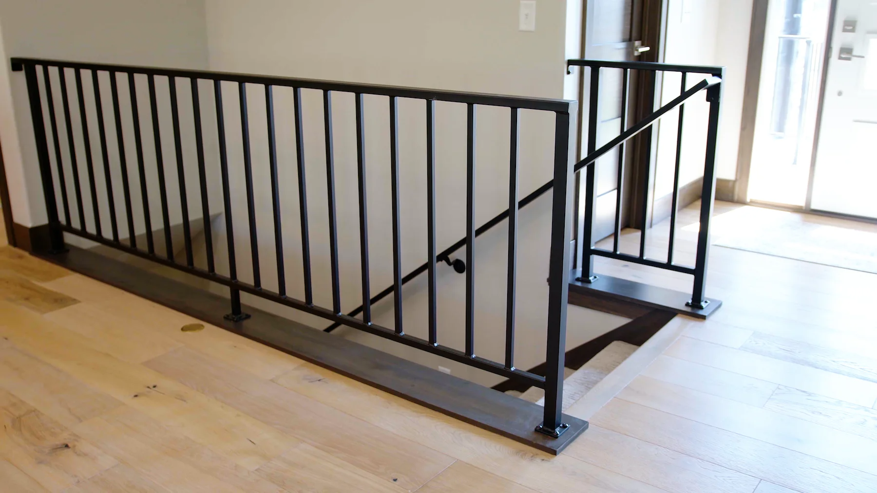 A staircase with a metal railing and a wooden floor.