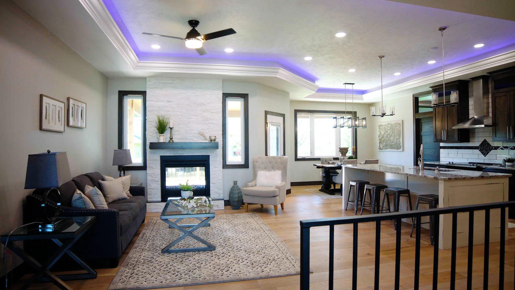 A living room with a fireplace and a purple ceiling light.