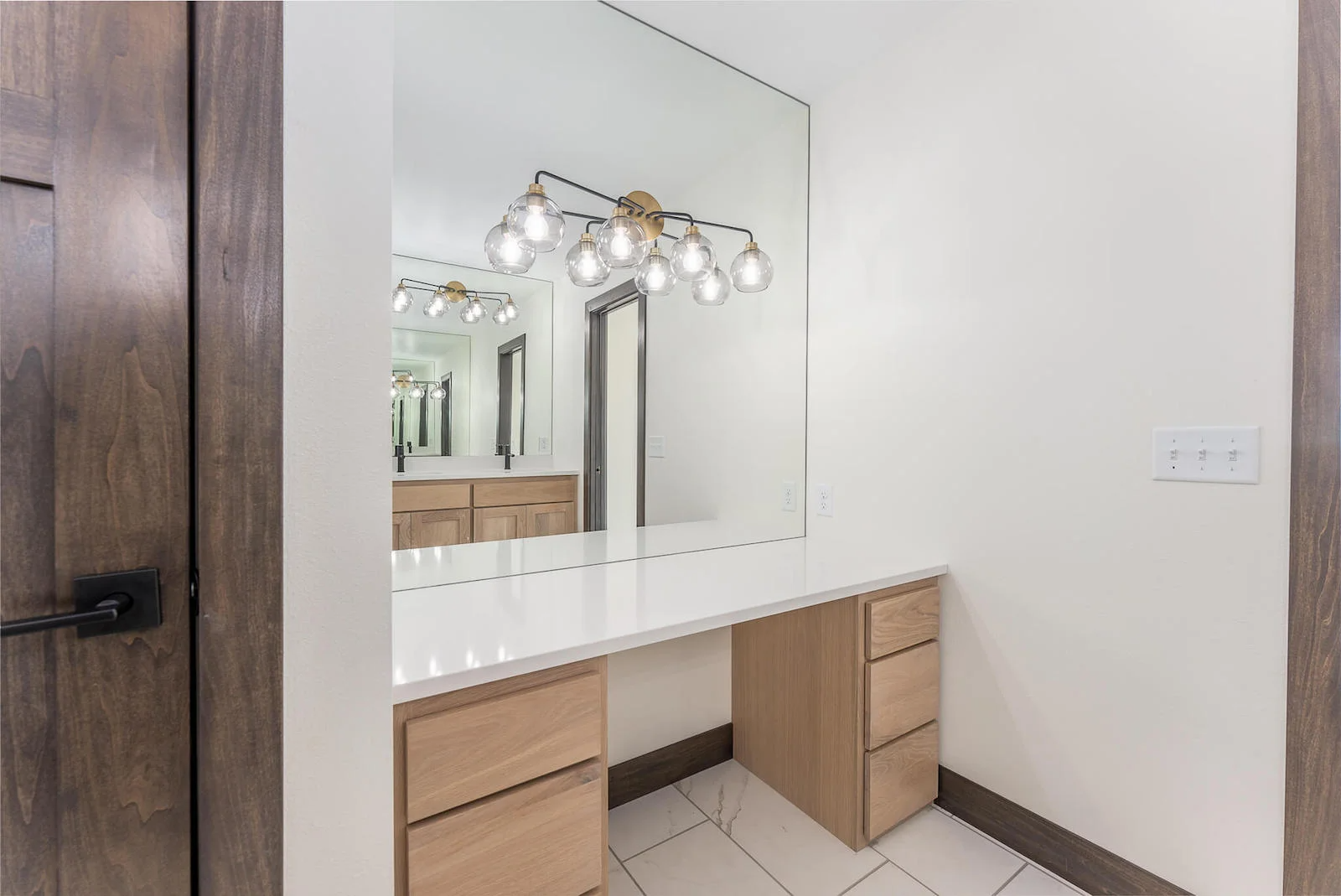 A bathroom with a vanity and a large mirror.