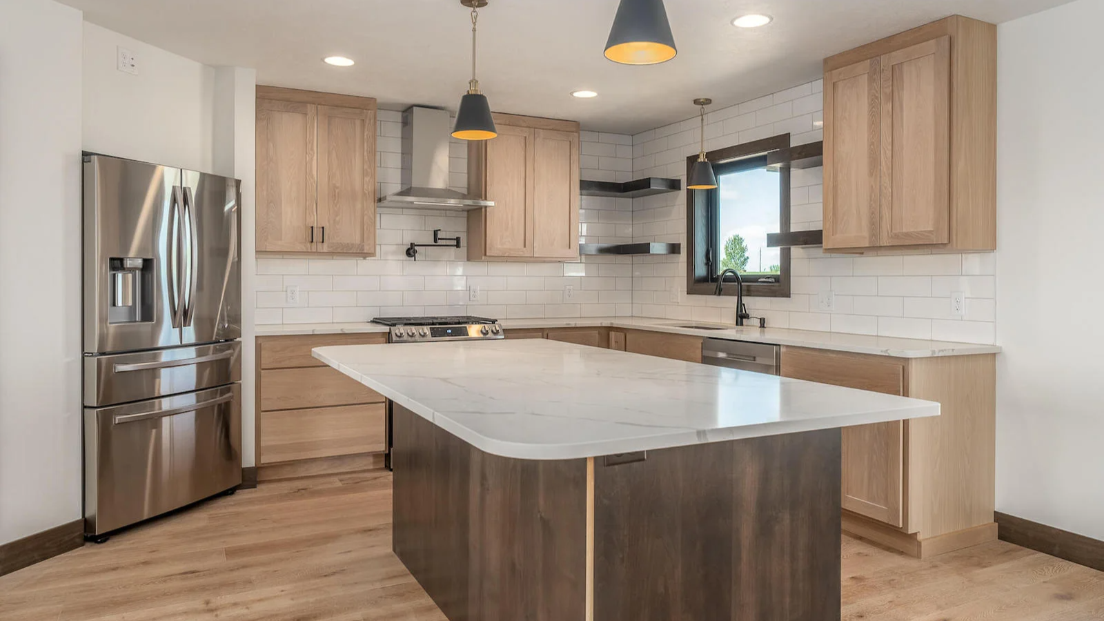 A kitchen with stainless steel appliances , wooden cabinets , and a large island.