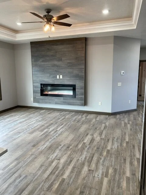 A living room with a fireplace and a ceiling fan