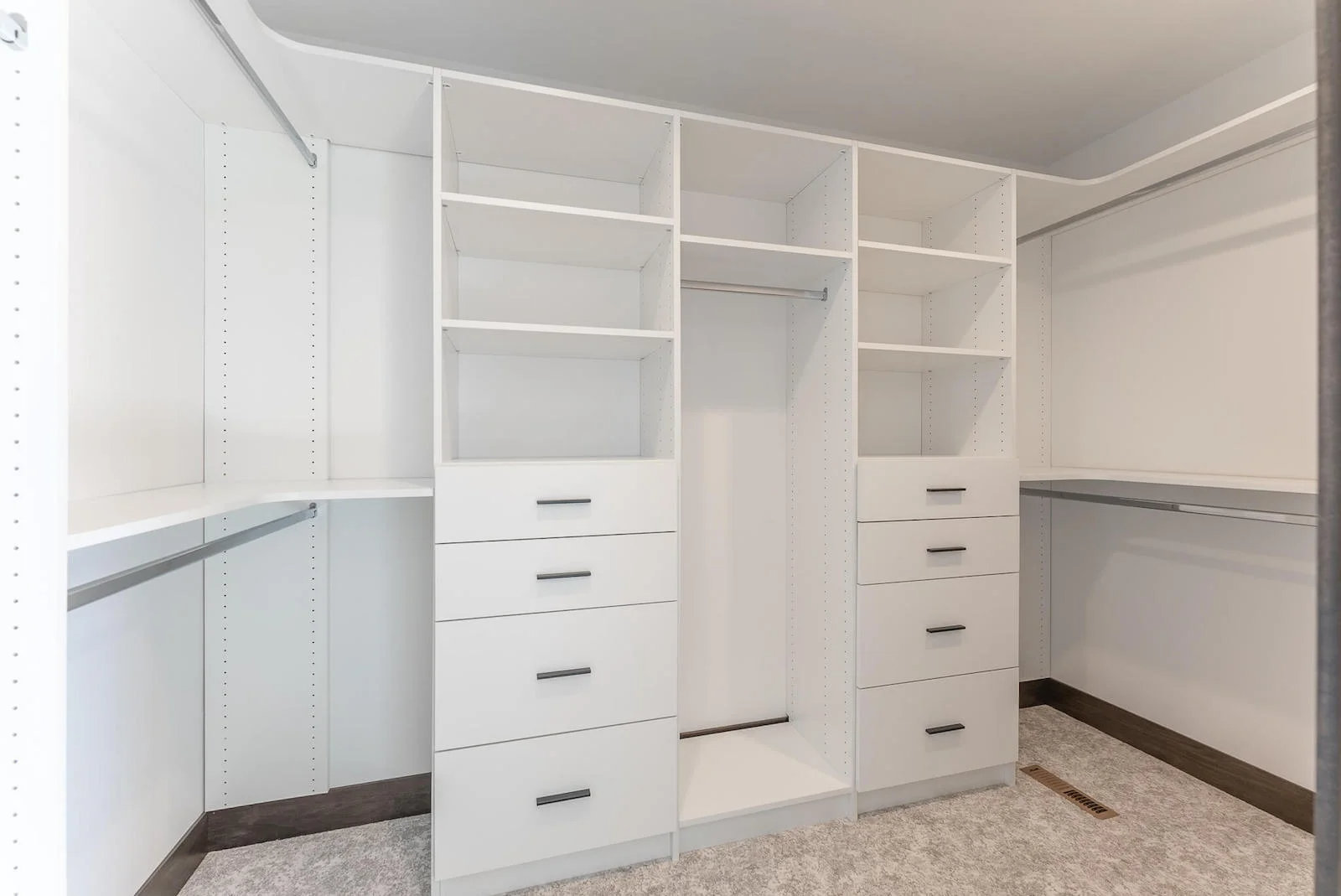 A walk in closet with lots of shelves and drawers.