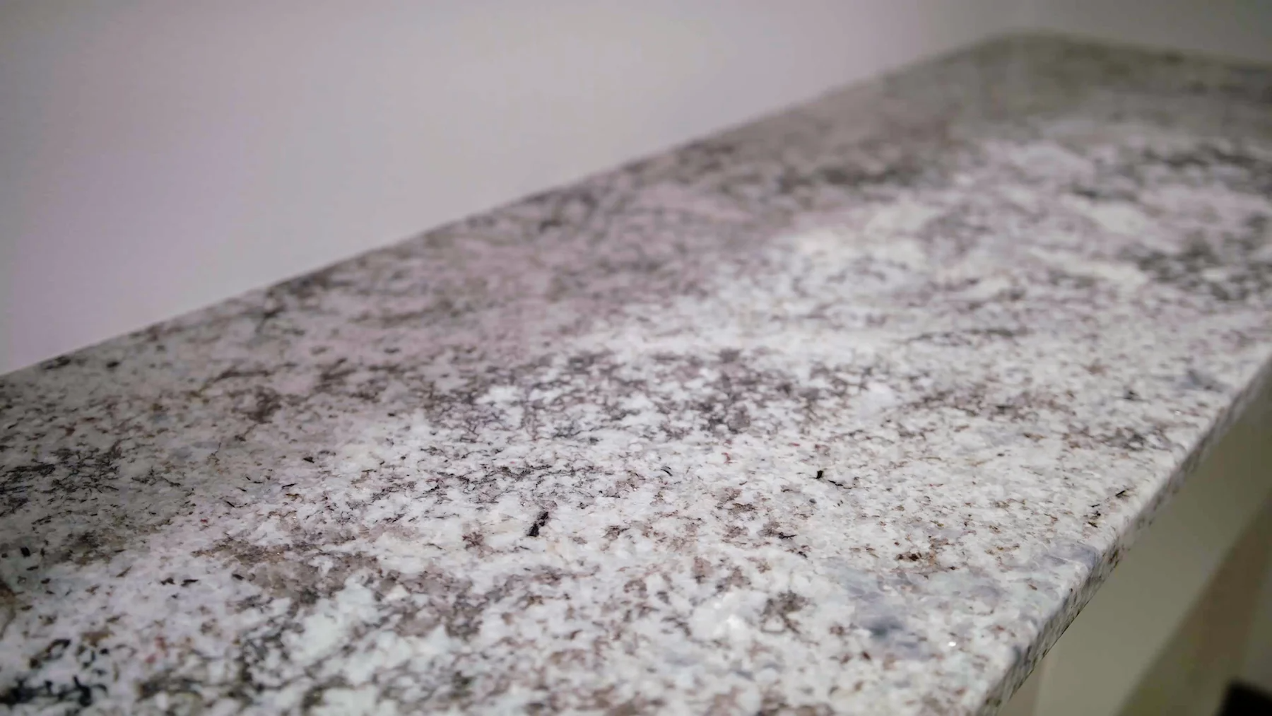 A close up of a white granite counter top.