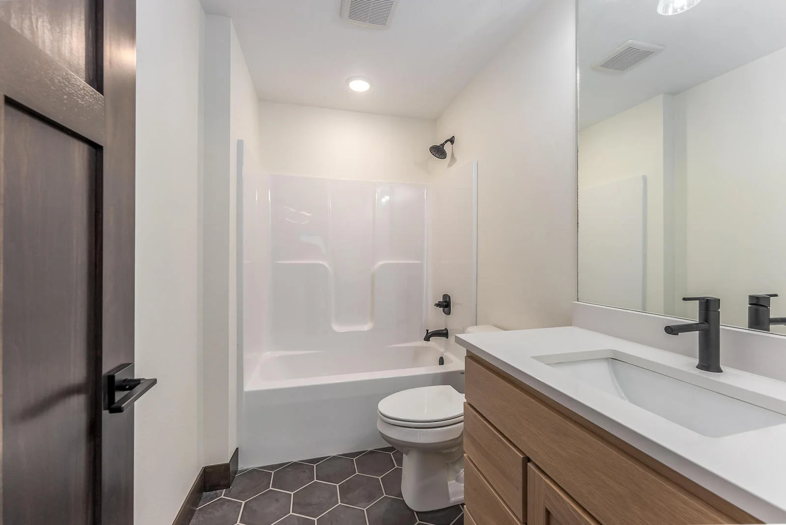 A bathroom with a toilet , sink and bathtub.