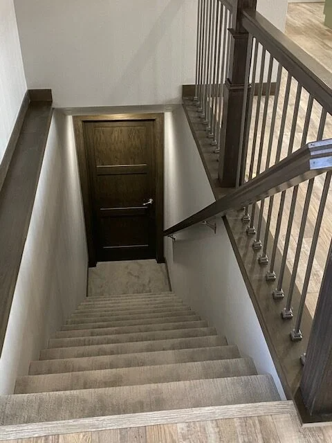 A set of stairs leading up to a door in a basement.