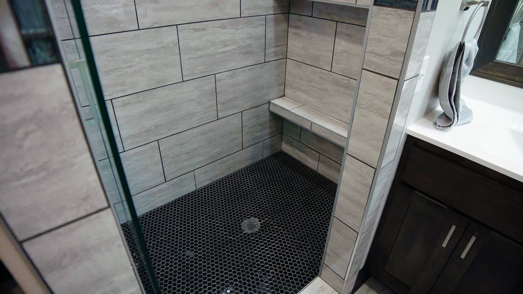 A bathroom with a walk in shower and a sink.