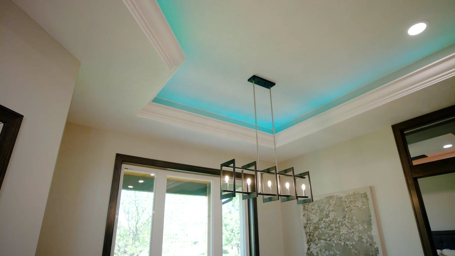 A dining room with a chandelier hanging from the ceiling.