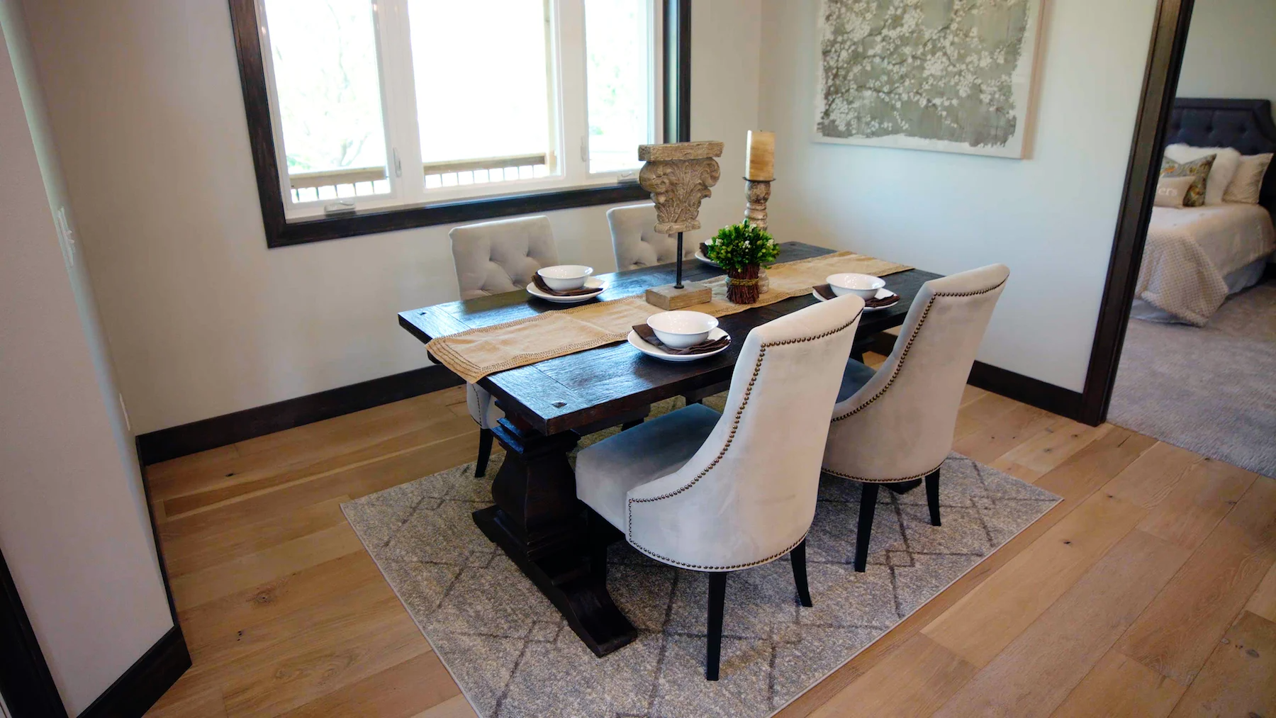 A dining room with a table and chairs and a rug.