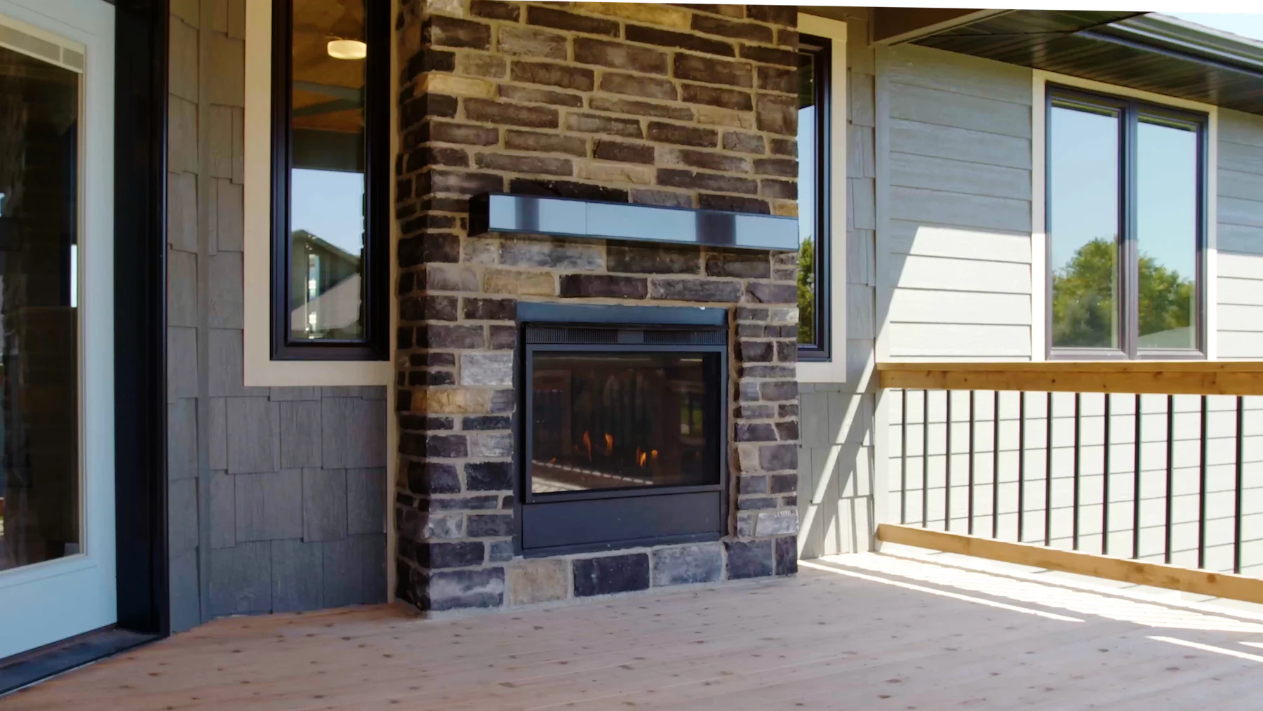 A brick fireplace is sitting on the deck of a house.