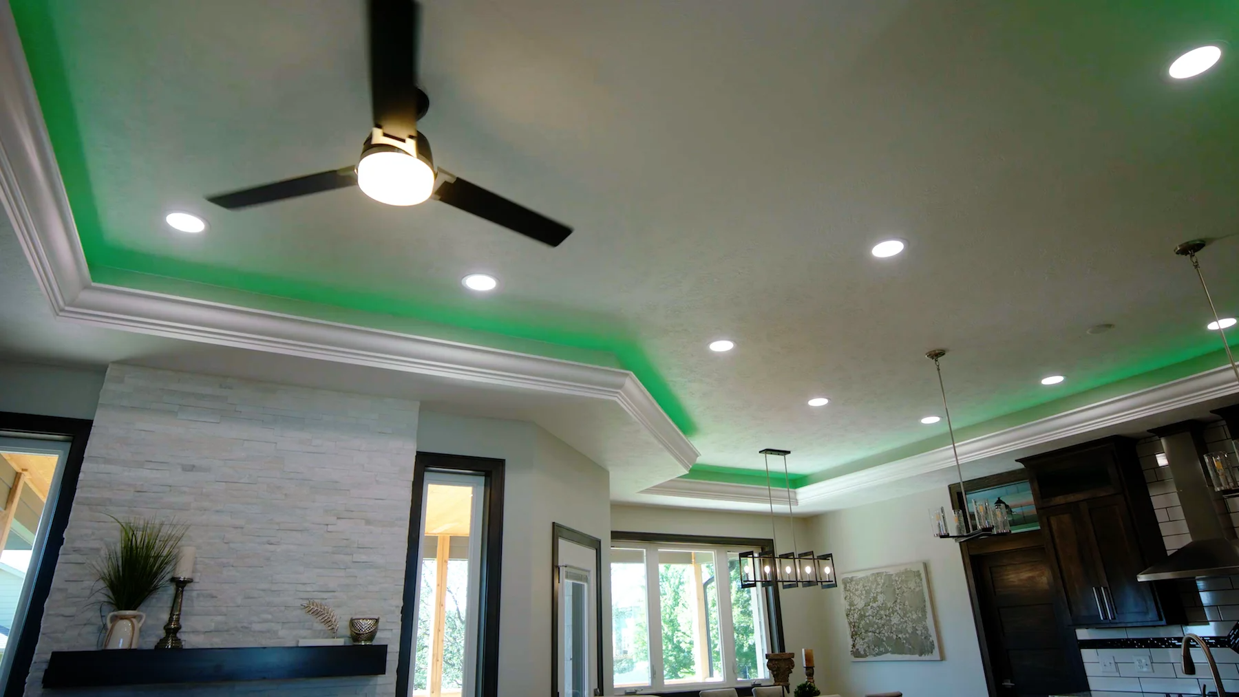 A living room with a ceiling fan and green lights.