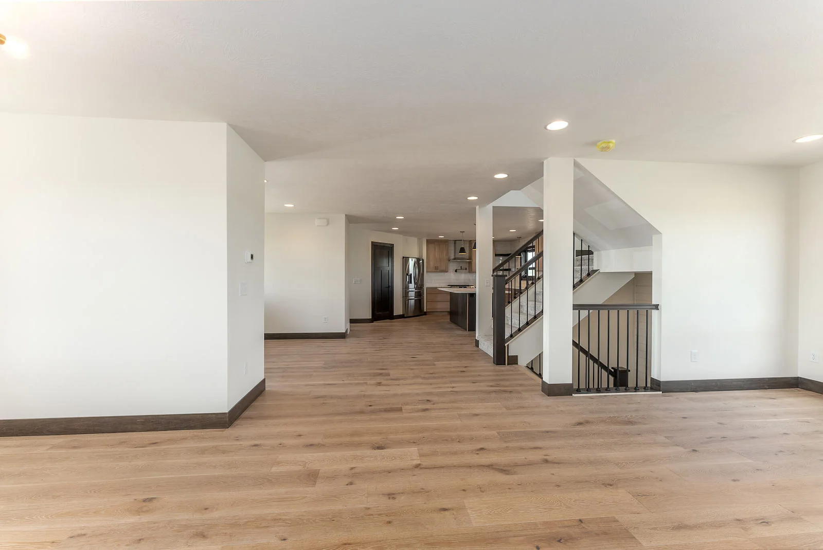 A large empty room with hardwood floors and white walls.