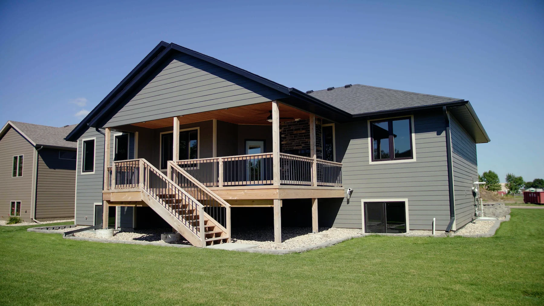 The back of a house with a large deck and stairs.