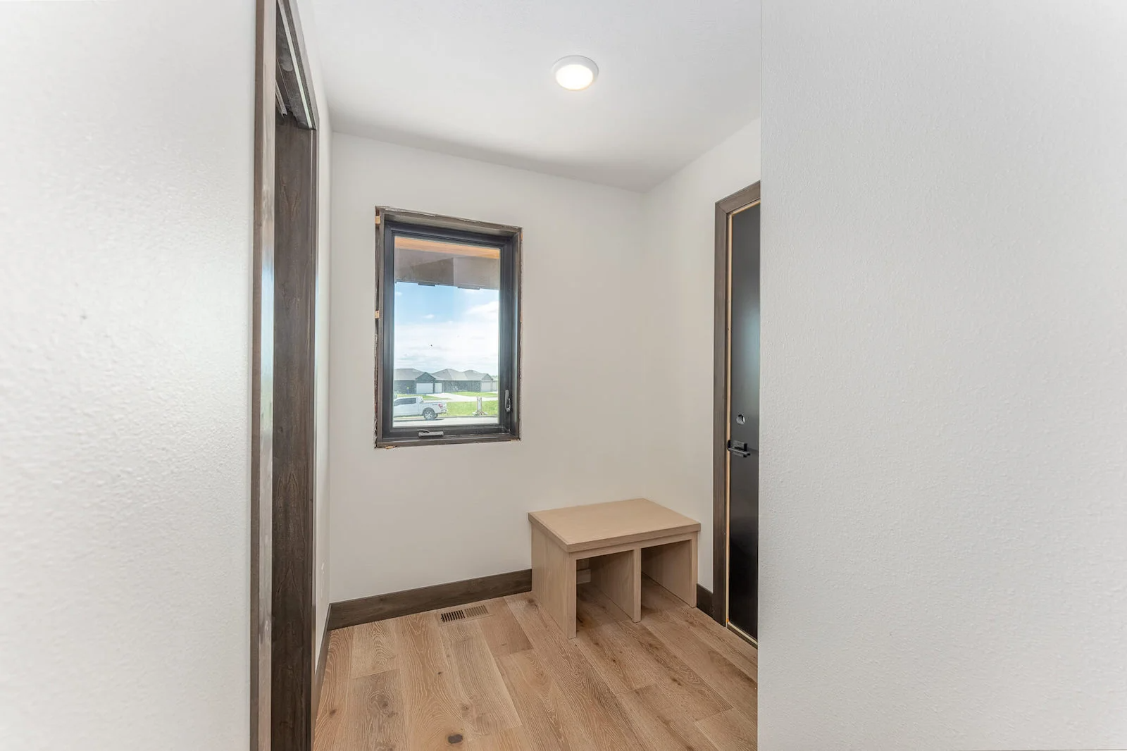 A hallway with a bench and a window in a house.