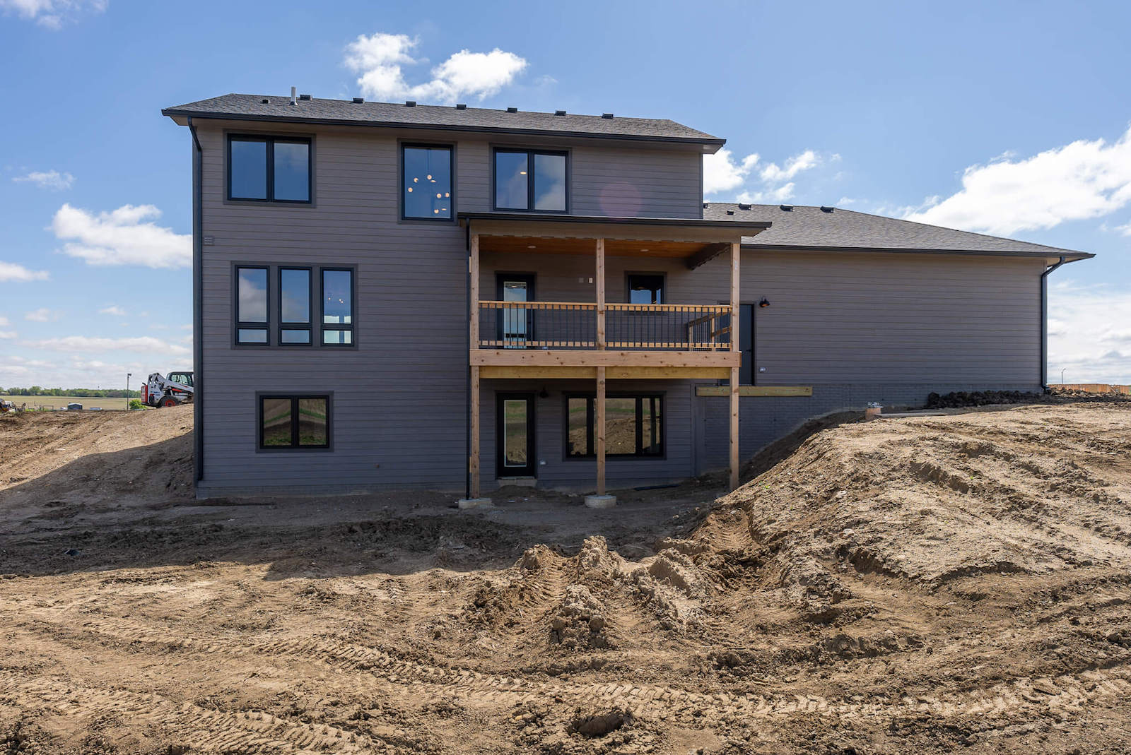 A large house is sitting on top of a dirt hill.