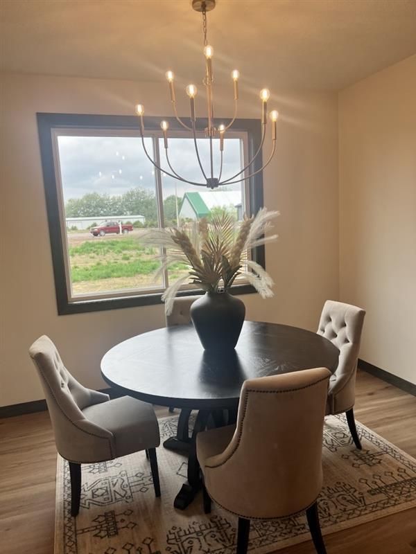 A dining room with a table and chairs and a chandelier.