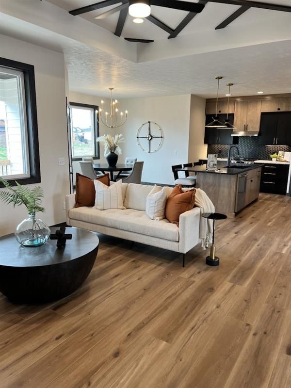 A living room with a couch, coffee table, and ceiling fan.
