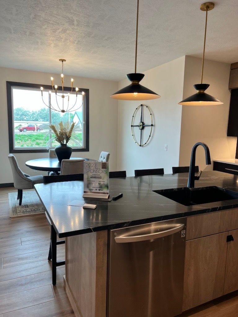 A kitchen with a large island and a clock on the wall.