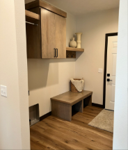 A hallway with a bench and cabinets on the wall