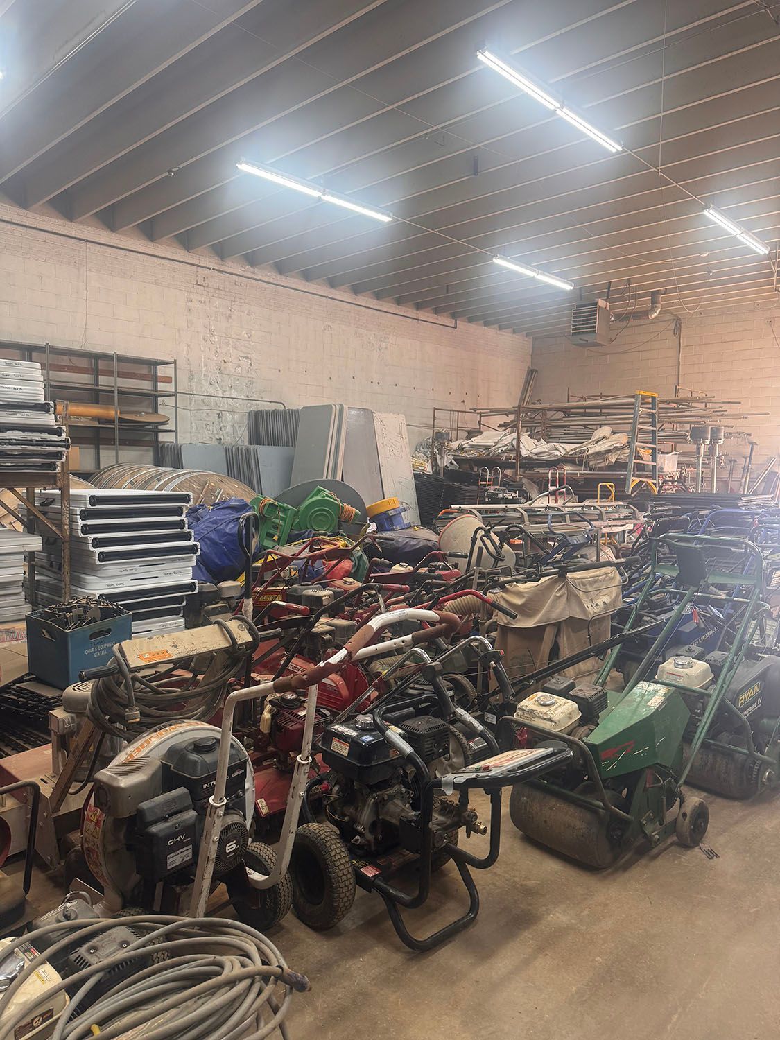 A large warehouse filled with lots of lawn mower equipment