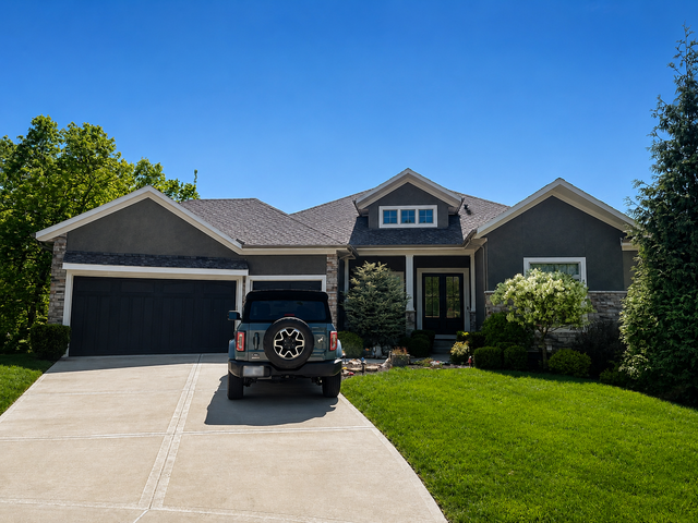 Suburban house with a black SUV in the driveway and a green lawn under a clear blue sky