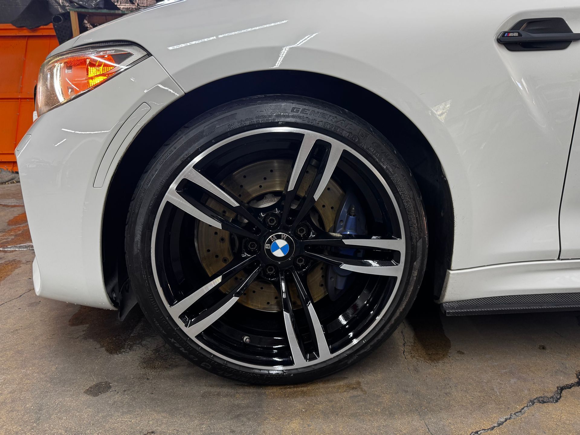 A close up of a white BMW with black wheels