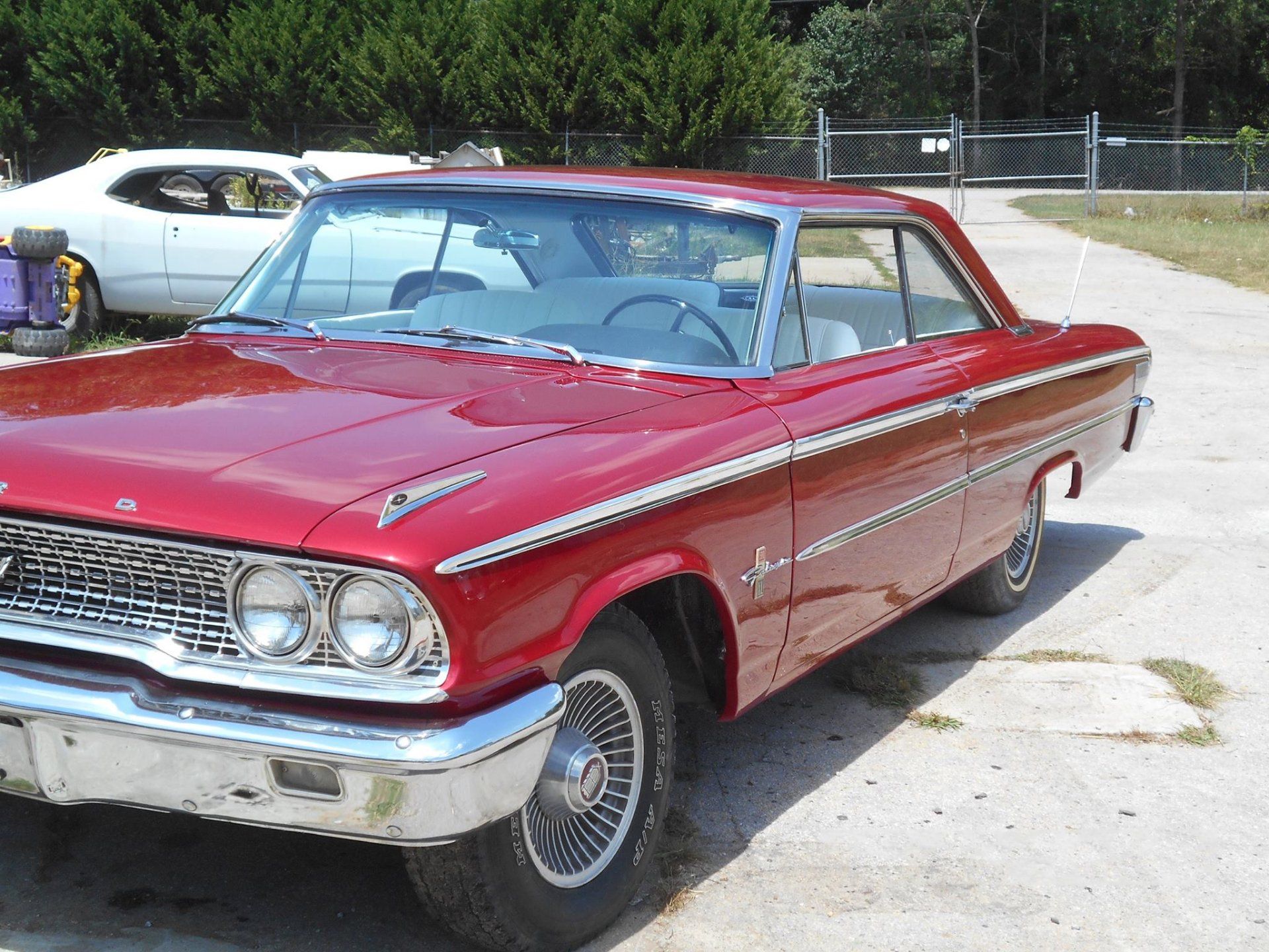 A red car is parked on the side of the road