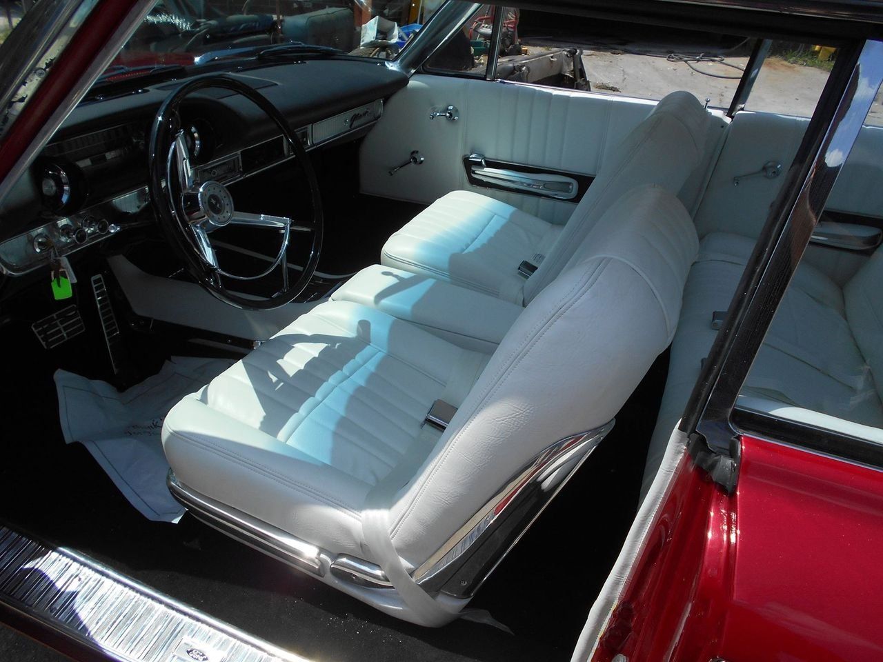 A red car with white seats and a steering wheel