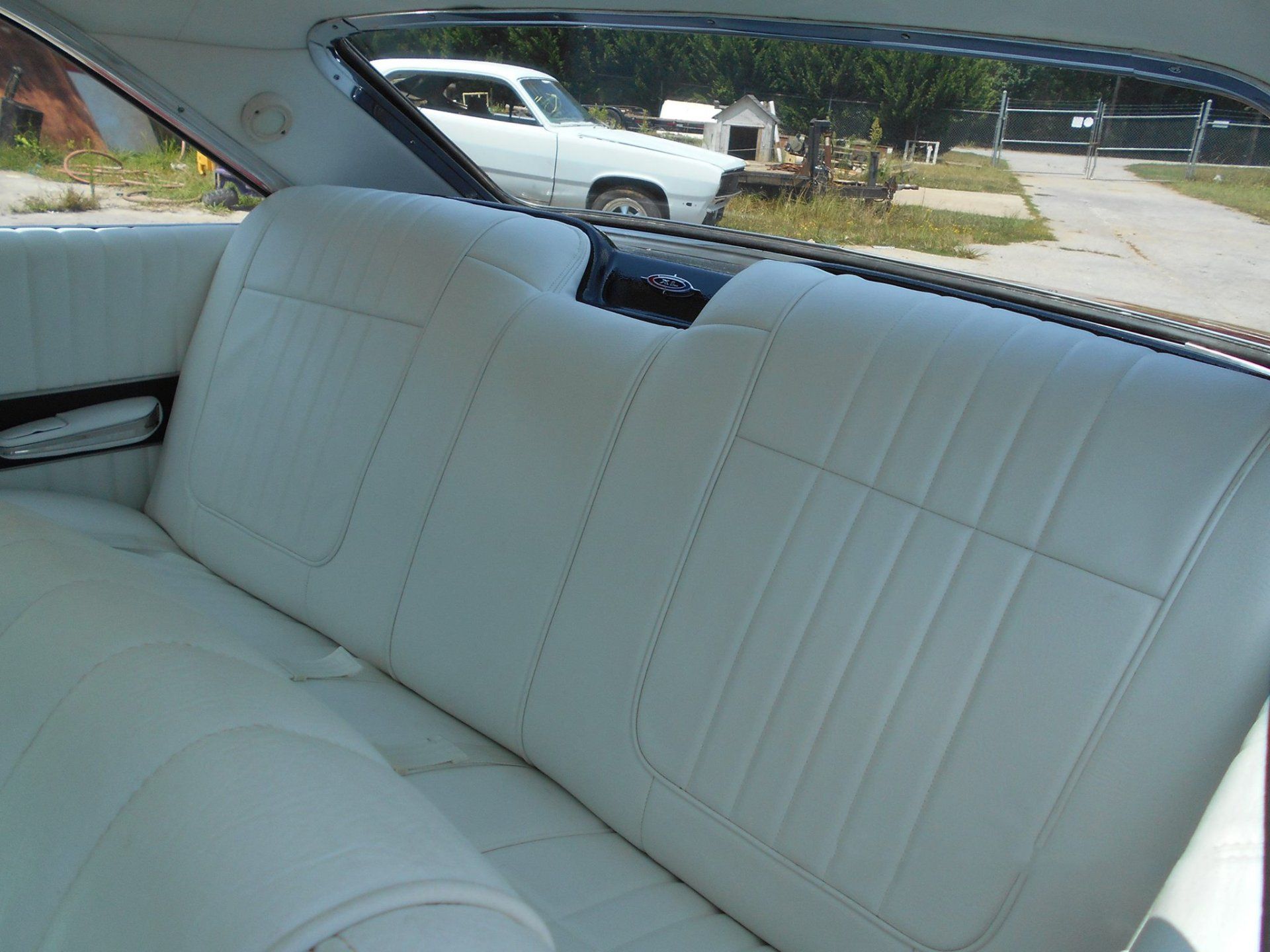 The back seat of a car with white leather seats