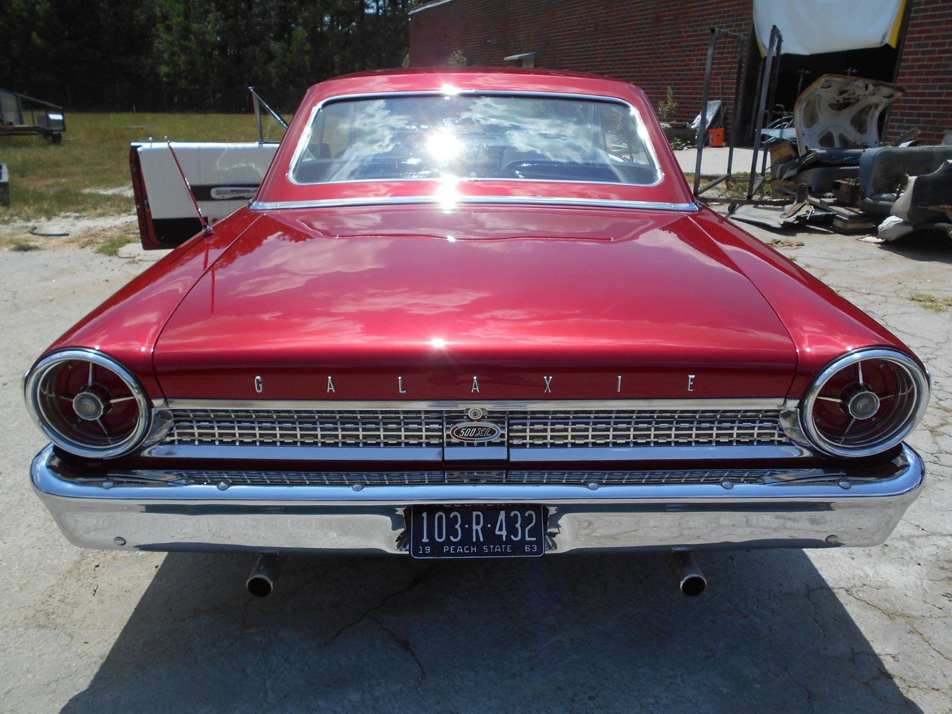 A red car with a license plate that says 103-r-432