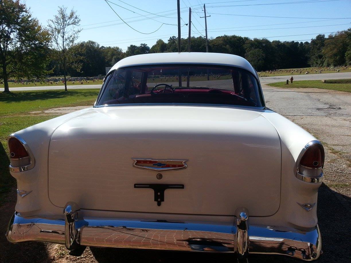 A white car is parked on the side of the road